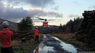 Rescue workers standing near a helicopter