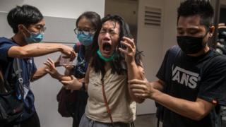 Çarşamba günü Hong Kong'daki protestolar sırasında bir kadın biber gazı ile vurdu