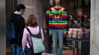 A couple look at outfits on display in the window of a Gucci shop on October 20, 2017 in Barcelona, Spain.