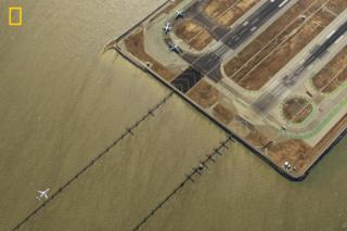 Aerial view of a plane coming in to land on a runway