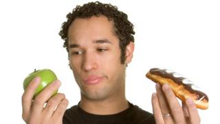 Hombre con una manzana y un dulce.
