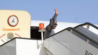Buhari dey wave as e tanda for door of plane