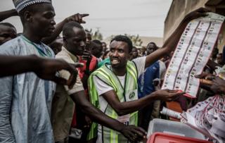 Electoral commission officers and voters talk while votes are counted at Shagari Primary School polling station in Yola, Adamawa State, on February 23, 2019 after the polls closed on the day of the general election