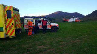 Members of the Mourne Mountain Rescue Team with an ambulance and an Irish Coast Guard helicopter
