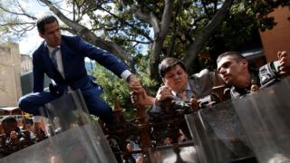 Juan Guaidó climbing a fence in front of the National Assembly