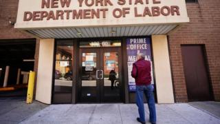 A man in front of a state Labor Department office