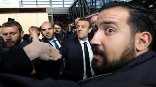 Benalla aparece em primeiro plano em foto de fevereiro, com Macron ao fundo