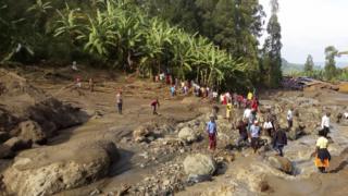 People gather at the scene of a landslide in Bududa area in eastern Uganda,