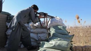 An Afghan Local Police (ALP) member keeps watch during a battle with Taliban militants in the Marjah district of Helmand Province (23 December 2015)