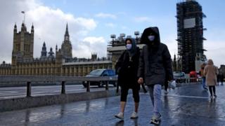 People with facemasks outside Parliament in Westminster