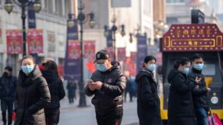 People wearing masks walking on the famous business street of Binjiang Dao, at downtown Tianjin.