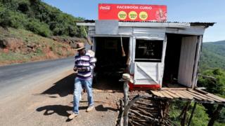 Harun Karanja, the owner of Facebook Curio Shop, uses his mobile phone to access his Facebook account near the Rift Valley town of Mai Mahiu, Kenya March 28, 2018.