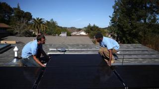 Работники SolarCraft Крейг Пауэлл (слева) и Эдвин Нил устанавливают солнечные панели на крыше дома 26 февраля 2015 года в Сан-Рафаэле, штат Калифорния.