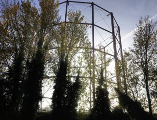 A steel structure behind trees