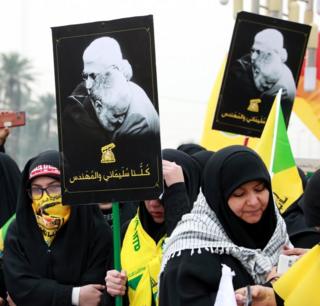 سيدات من أنصار كتائب حزب الله العراقي يحملن صور سليماني والمهندس خلال تشييعهما في بغداد.
