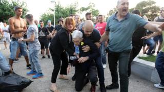 Yardımcıları, belediye başkanını yerden kaldırmaya çalışırken