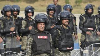 Soldados paramilitares paquistaníes se posicionan cerca de seguidores del grupo religioso "Tehrik Labayk Ya Rasool Allah (TLYRA)" durante una protesta en Islamabad, a fines de noviembre.
