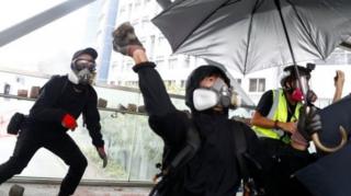 Pengunjuk rasaa melempar batu ke jembatan saat protes anti-pemerintah di dekat City University pada hari Selasa.