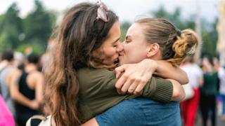 dos mujeres besándose