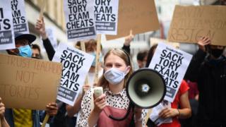 People take part in a protest outside the Department of Education in Westminster, London