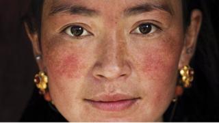 摄影师米哈艾拉在乡村遇到了有两个孩子的藏族母亲。米哈艾拉说,"她当时戴着首饰在打扫房屋"。