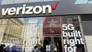 People wait in line at a Verizon store during the coronavirus pandemic.