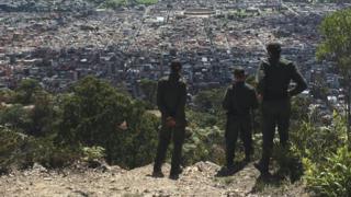 Policías miran la ciudad desde el cerro.