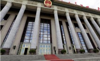 An officer stands outside the Great Hall of the People, the venue of National People"s Congress, China"s parliament, in Beijing, June 18, 2015.