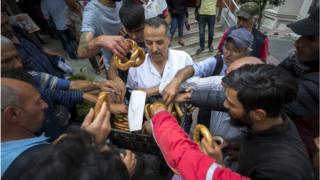 Imam Osman Gokrem (C) offers bagels to homeless people at the historic Selime Hatun Mosque a small Muslim house of worship dating back to the 17th century at the center of a populous Beyoglu district