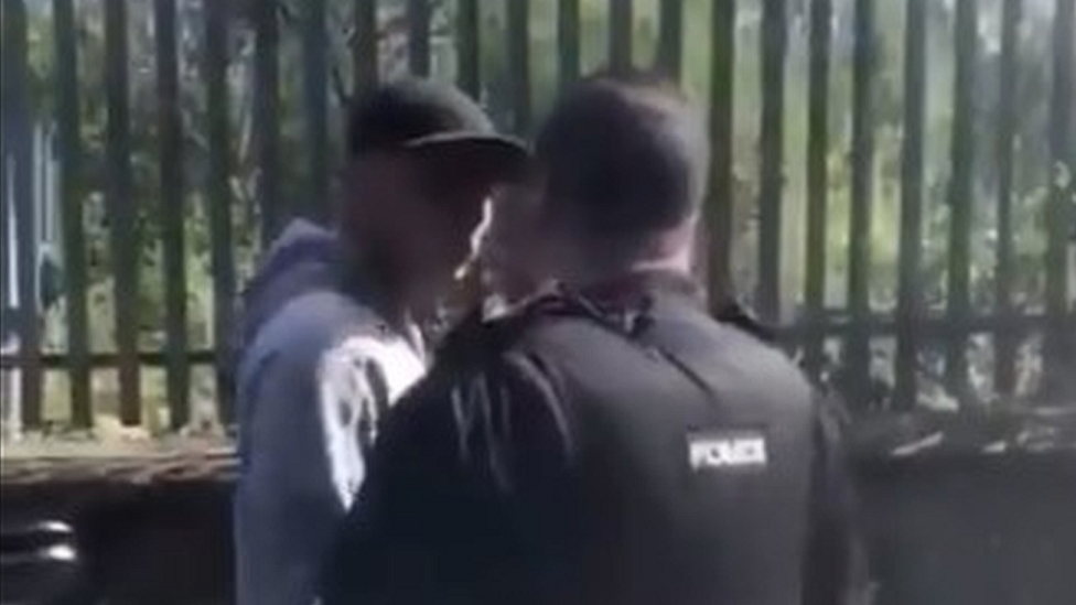 Still show police officer talking to arrested man