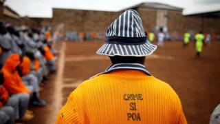 A Kenyan prisoner wearing a shirt with the words "Crime is not good" watches a mock world cup soccer match between Russia and Saudi Arabia, as part of a month-long soccer tournament involving eight prison teams at the Kamiti Maximum Prison, Kenya"s largest prison facility, near Nairobi,