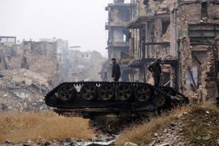 Силы, верные президенту Сирии Башару Асаду, стоят на поврежденном танке возле мечети Омейядов в Алеппо, 13 декабря