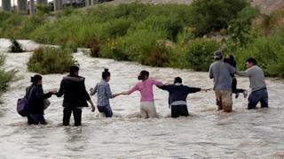 Central American migrants form a human chain that crosses the Rio Bravo to illegally enter the United States and go to seek asylum in El Paso (Texas, USA), as seen from Ciudad Juarez ( Mexico) on June 11, 2019.
