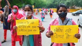 Workers in New Delhi, India on 9 August protest at a lack of protection from Covid-19