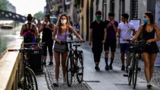 People stroll through the Navigli channels in Milan on May 8, 2020