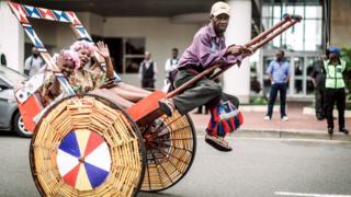 A rickshaw puller gestures as hundreds of people dressed in traditional attire in Durban take part on May 26, 2018 in a street carnival festival celebrating Africa Month