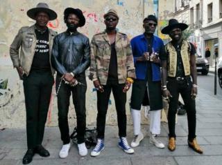 Amah Ayivi wearing Marche Noir on streets of Paris with friends