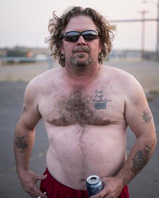A man holds a beer can