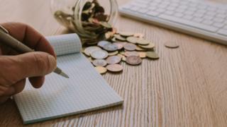 moedas e papel de anotações
