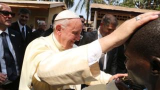 Pope Francis greets children during his visit to refugee camp of Saint Sauveur in Bangui, Central African Republic