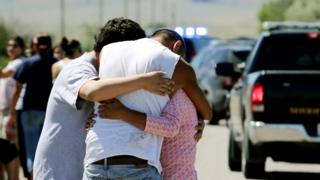 Family members embrace at the scene of a shooting in Pryor, Montana, on the Crow Reservation on 29 July