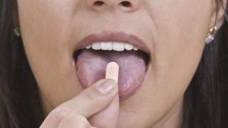 Mujer tomando una pastillla