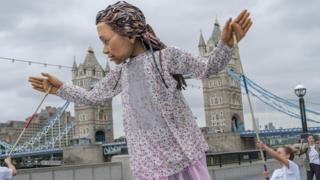 Little Amal in front of Tower Bridge