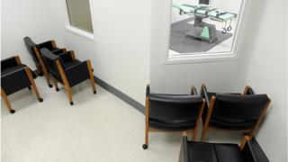 Chairs facing a window into the execution room