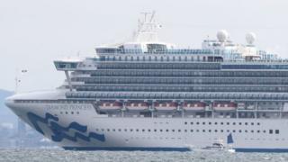 A small boat is pictured next to the Diamond Princess cruise ship