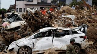Carro destruído em meio a destroços causados por chuvas torrenciais no Japão
