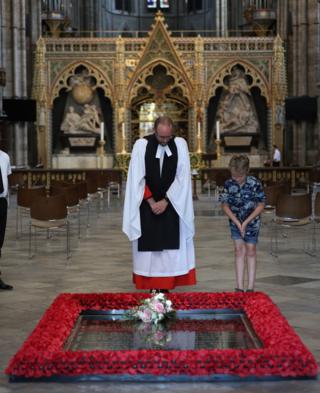 Der Reverend Canon Anthony Ball mit Toby Wright, dem Sohn des Reverend Paul Wright, Unterdekan der Chapel Royal, der Prinzessin Beatrices Blumenstrauß von der Hochzeit mitbrachte, um ihn auf das Grab des unbekannten Kriegers zu legen