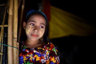   Romzida, an 8-year-old Rohingya refugee, poses for a photo while she carries a thanaka paste at Shamlapur camp at Cox Bazaar in Bangladesh 