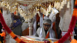 Sikh pilgrims take part in a religious ritual as they gather to celebrate the 550th birth anniversary of Guru Nanak Dev, at Nankana Sahib