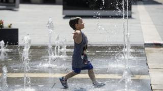 A young boy runs through a fountain in Hungary